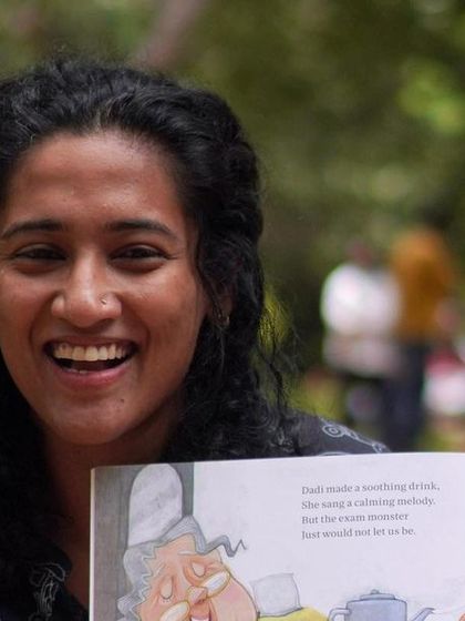 A joyful, candid shot of me laughing while reading. This captures the fun and lighthearted spirit that I strive to bring to every single storytelling session.
