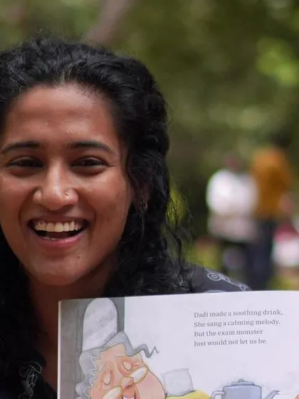 A joyful, candid shot of me laughing while reading. This captures the fun and lighthearted spirit that I strive to bring to every single storytelling session.
