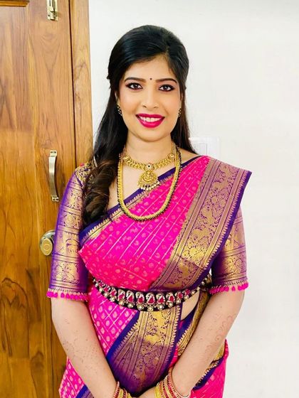 A forever favorite look for a treasured client. This vibrant pink and violet Kanchipuram silk saree is paired with a custom-designed blouse, creating a timeless and elegant ensemble for her special occasion.