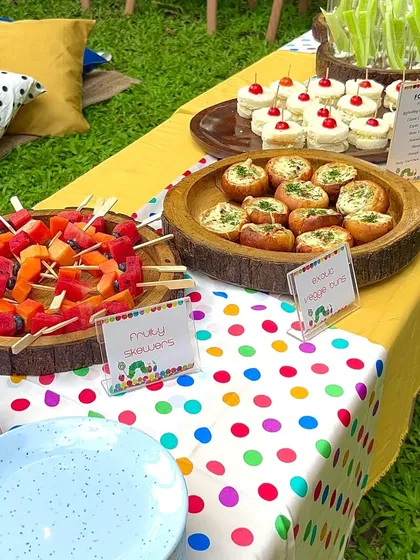 I believe party food should look as good as it tastes. This vibrant spread for a 'Very Hungry Caterpillar' themed party features colourful fruity skewers, mini veggie buns, and other aesthetic treats that are ready for their close-up.