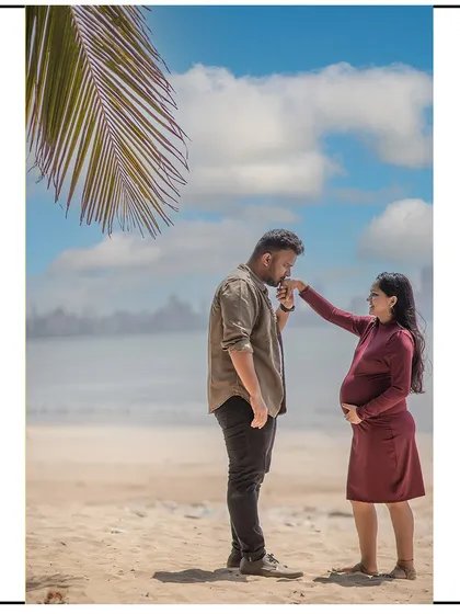 A romantic kiss on the hand against the backdrop of the sea. A beach maternity shoot provides a beautiful and timeless setting for couple portraits.