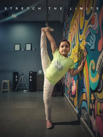 We help kids discover what their bodies are capable of. Here, one of my dedicated students shows incredible flexibility during a stretching session at our studio, proving that with practice, you can stretch your limits.