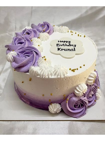 A blueberry-flavored cake with purple and white ombre frosting and piped rosettes. The gold sprinkles add a final touch of elegance.