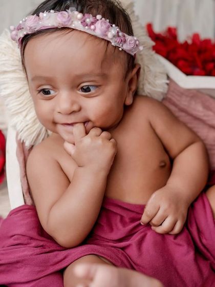 A cheeky little grin. This older baby is full of personality, and I love capturing these fun, interactive moments.