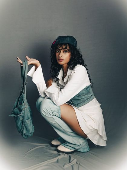 A full look with an accessory, showing how to style the outfit. This is a useful shot for a brand's lookbook or social media.