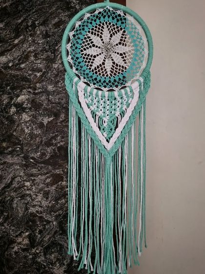 Grace your space with our enchanting mint-hued macrame dreamcatcher. This piece features a tree of life design, adding a layer of beautiful symbolism.
