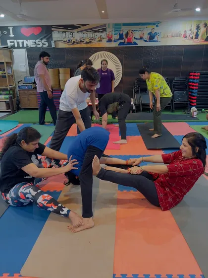 I am always there to provide hands-on assistance and ensure your alignment is correct and safe. In this partner stretch, I am helping a student get a deeper, more effective stretch in their hamstrings.