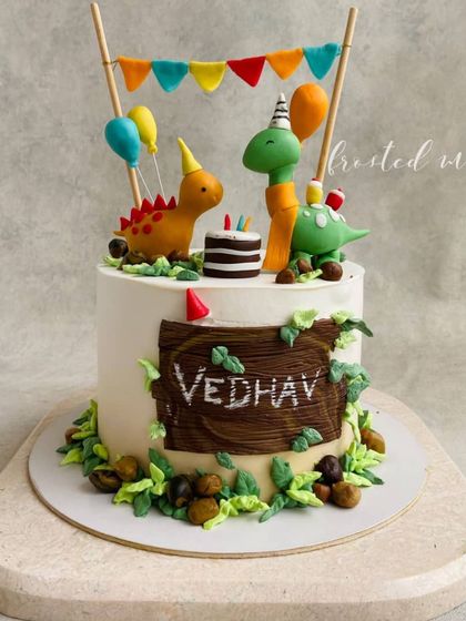 A roarsome party with friendly dinosaurs! This cake features cute, hand-sculpted dinosaurs celebrating with party hats and balloons. It’s a fun and playful design perfect for a little one's birthday.