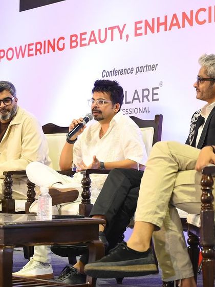 A candid moment during the panel discussion, emphasizing a point about the evolving salon business landscape.