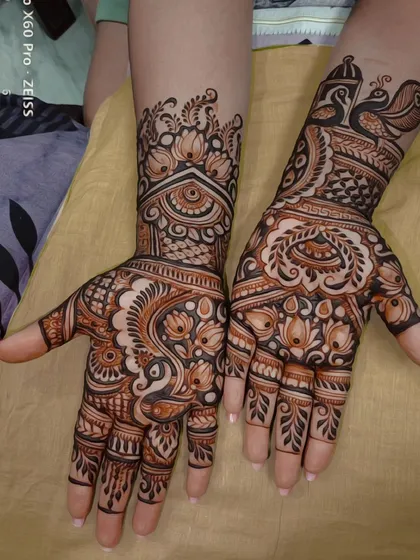 This design showcases a mix of bold and fine lines. It features prominent lotus and peacock motifs, which are symbols of beauty and grace, combined with delicate jaali (net) patterns for a balanced composition.