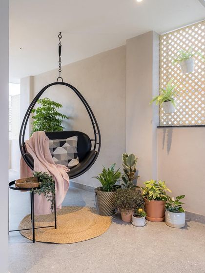 A hanging swing chair surrounded by greenery creates a perfect reading nook on this balcony. It’s a simple way to design a moment of peaceful escape within the home.