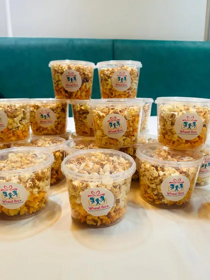 Freshly packed and ready to go. These tubs of crunchy, flavorful popcorn are a great way for guests to take a piece of the party home with them.