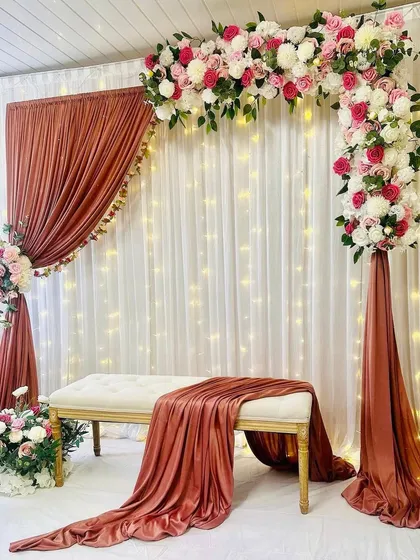 Here is another view of the pretty rust and pink floral stage. This angle shows how the side floral piece and the main arch come together to frame the seating area beautifully. I always make sure the decor looks great from every perspective for your photos.