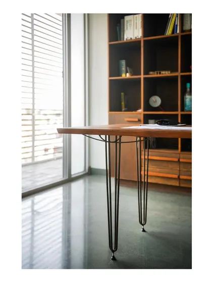 A detail shot of our studio workstation table. The slender steel rods are not just decorative; they are woven to represent the actual force diagrams of the structure, making the engineering itself the primary aesthetic feature. This is a core tenet of our design approach.