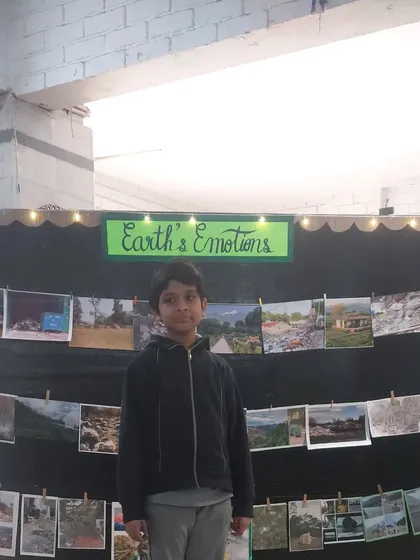 A student stands by his "Earth's Emotions" display, which was part of his science exhibition project. It was a creative way to show the impact of pollution on our planet.