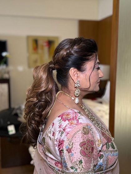 A creative style that combines a braid at the crown with a voluminous ponytail. This adds interesting texture and detail to the look.