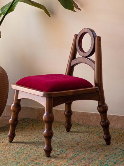 The Manjadi Chair is a conversation starter, inspired by the 'Manjadikuru' or Red Lucky Seed from Kerala. Designed as a statement piece, its playful form and unique details, like the seed-pod-shaped legs, invoke a sense of curiosity and childhood nostalgia.