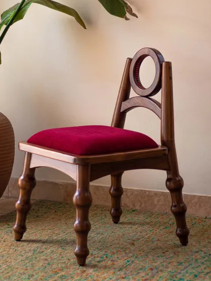 The Manjadi Chair is a conversation starter, inspired by the 'Manjadikuru' or Red Lucky Seed from Kerala. Designed as a statement piece, its playful form and unique details, like the seed-pod-shaped legs, invoke a sense of curiosity and childhood nostalgia.