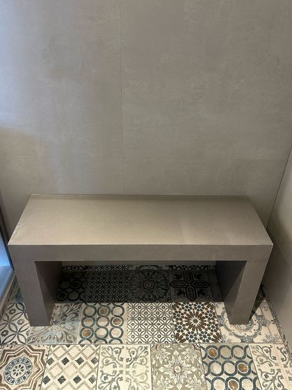 Simplicity can be very powerful. In this shower nook, a clean, minimalist concrete bench sits on a floor of beautiful Moroccan-inspired tiles, creating a functional detail that is also a moment of beauty.