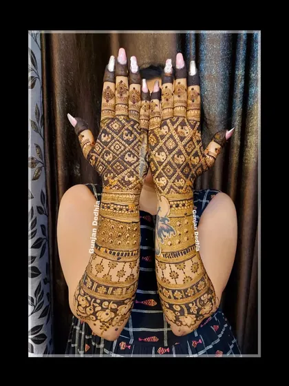 A stunning back-hand design with intricate checkerboard patterns featuring tiny elephants. This level of detail is what makes bridal mehendi so special.