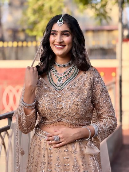 This bride is all smiles in her beautiful beige lehenga. I styled her hair with soft waves and a center part to complement her maang tikka.