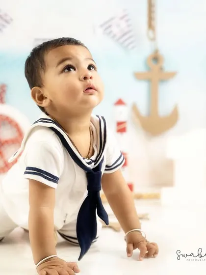 Looking up in wonder. This crawling pose captures the curiosity and energy of this little sailor.