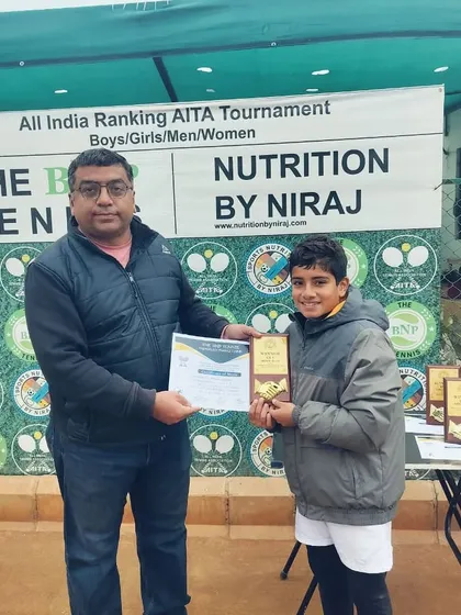 Mayank Saharan, the youngest player in the final four, wins his first AITA CS U-14 singles title. He is shown here receiving his award in front of the official tournament banner.
