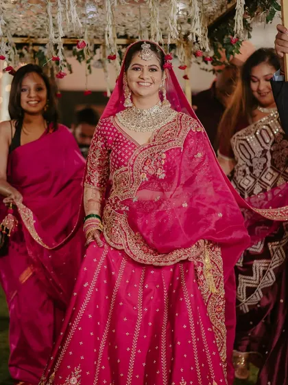 The bride's grand entrance. She looks absolutely radiant and confident as she walks in, surrounded by her loved ones.