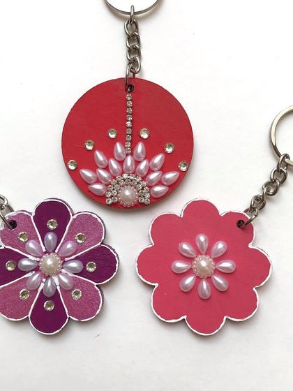 Here are the fronts of some of my floral keychains. I use a combination of paint, pearls, and rhinestones to create different decorative patterns, making each one a unique piece of art.