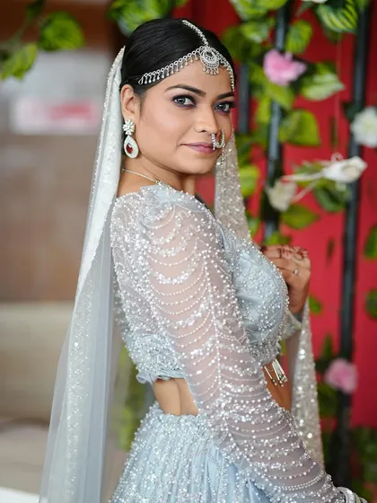 For a modern reception or engagement, a look like this is perfect. We chose a soft glam style with shimmery eyeshadow, a defined brow, and elegant diamond jewelry to match her stunning silver lehenga.