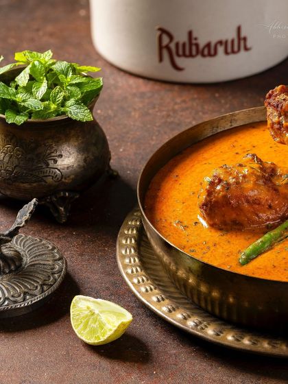Another perspective of the Chicken-e-Rubaruh, highlighting the fresh mint and lime, suggesting the dish's flavor profile.