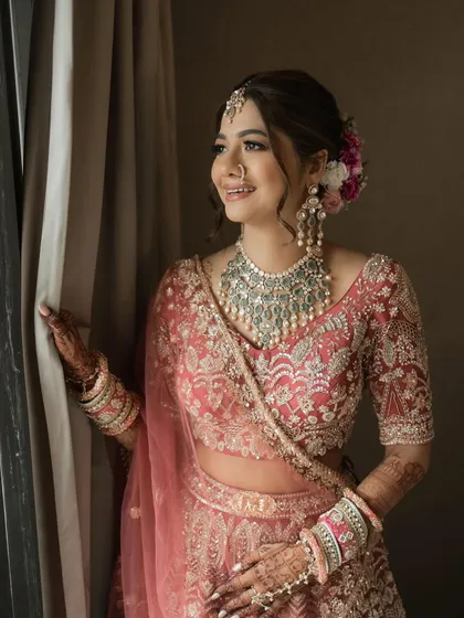 A moment of reflection before the big day. This full-length view showcases how the grand polki necklace completes her bridal ensemble, adding a layer of heritage and luxury.