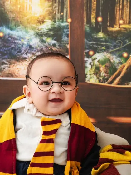 A close-up of our adorable baby wizard, his happy smile showing just how much fun a themed photoshoot can be.
