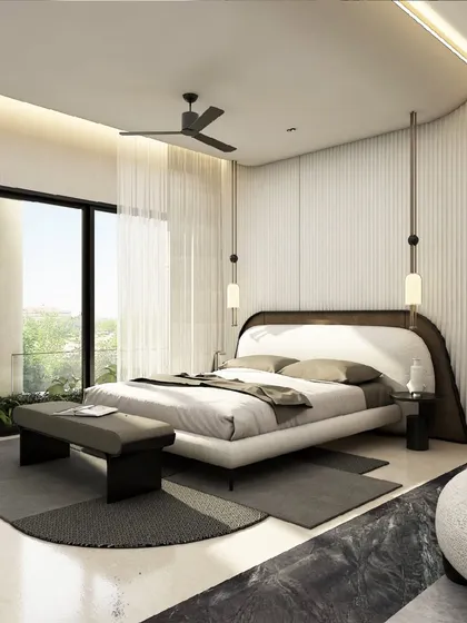 This bedroom is conceived as a tranquil retreat. A custom curved headboard and suspended pendant lights create a soft, inviting focal point, while the minimalist palette and floor-to-ceiling windows maintain a sense of airiness and connection to the view outside.