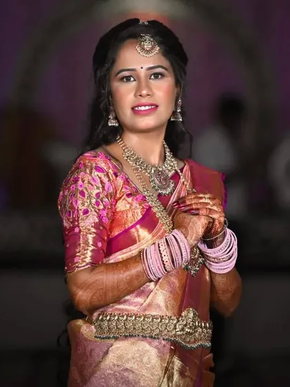 A classic pose showing her complete traditional attire. The makeup brings the whole look together, making her look like a quintessential South Indian beauty.