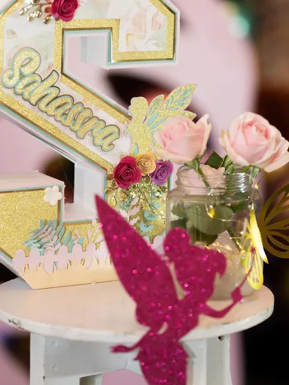 Another personalized name sign for 'Sahasra', decorated with glitter, paper flowers, and fairy cutouts. These custom pieces make great keepsakes.