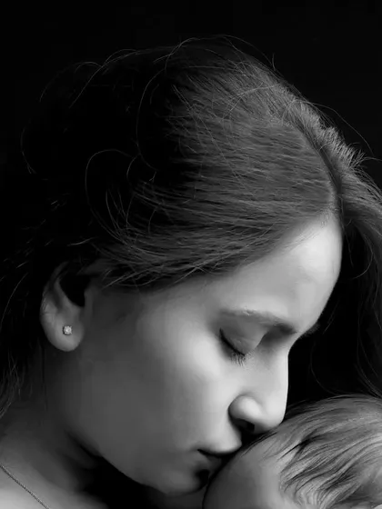A detailed close-up shot capturing the quiet intimacy of a mother and her newborn. These macro shots are perfect for remembering the delicate features and peaceful moments of infancy.