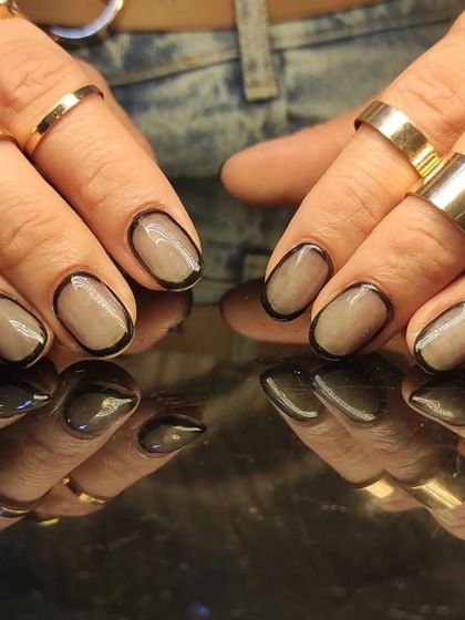 A trendy "outline" manicure with a black border around a sheer grey-nude nail.