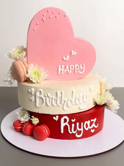 A full shot of the heart-shaped birthday cake, personalized with the name "Riyaz."