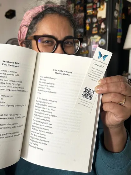 A published poet proudly shows her poem, 'Who Walks in Beauty?', printed in the anthology. Every participant who gets published receives a free copy.