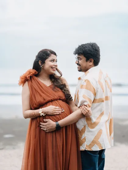 The way they look at each other says it all. This beach maternity shoot captures the pure joy of expecting, with her in the flowing rust-colored gown and him in a casual, complementary shirt.