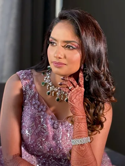 This shot captures the intricate details of her makeup and the beautiful henna on her hands.
