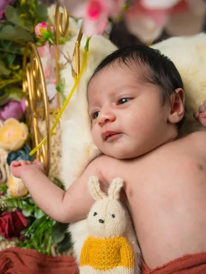A curious gaze from a garden of dreams. This awake shot shows the baby looking at the flowers, a sweet and interactive moment.