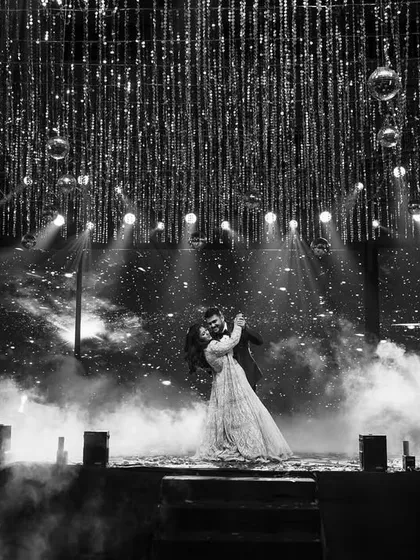 A black and white shot capturing the romance of the first dance, with dramatic smoke and lighting effects.