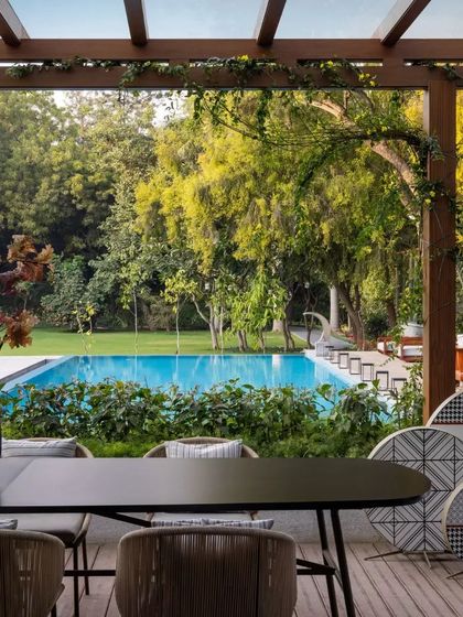 The view from the covered terrace out to the swimming pool and lush greenery. This 2.5-acre property was transformed while respecting local byelaws that restricted changes to the building's original form.