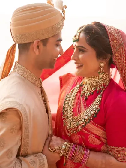 This bride's look was all about royal elegance. The makeup features a classic winged liner and a bold lip, paired with a traditional red saree and heavy jewelry for a truly regal appearance.