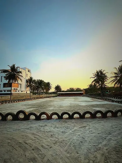 The main sand arena at sunset, an empty canvas ready for any event. The palm trees and city buildings in the distance create our unique urban ranch vibe.