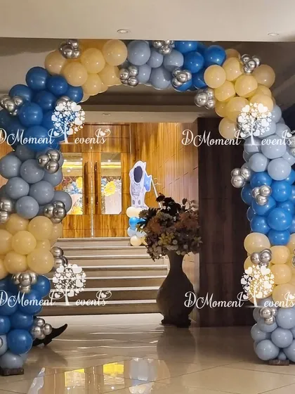 A simple and elegant balloon arch in shades of blue and beige with silver accents, perfect for a sophisticated party entrance.