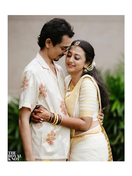 A beautiful moment between the newly married couple, both in traditional Kerala attire. The bride's set mundu is draped for elegance and comfort.