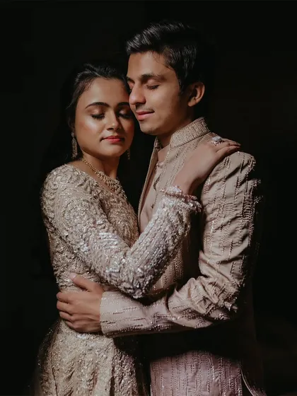 A romantic, softly lit portrait of a couple embracing with their eyes closed.